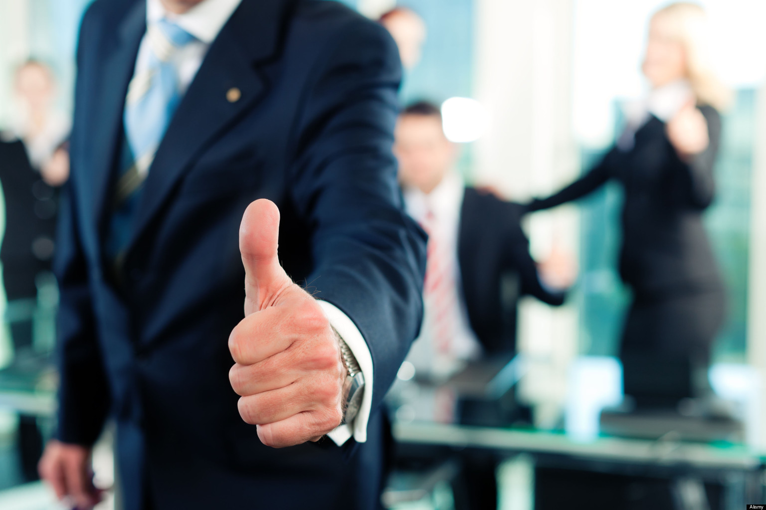 Business – team in an office; the senior executive has the thumb up; focus on thumb Mesurer enfin la « culture du résultat » comme mode de management .